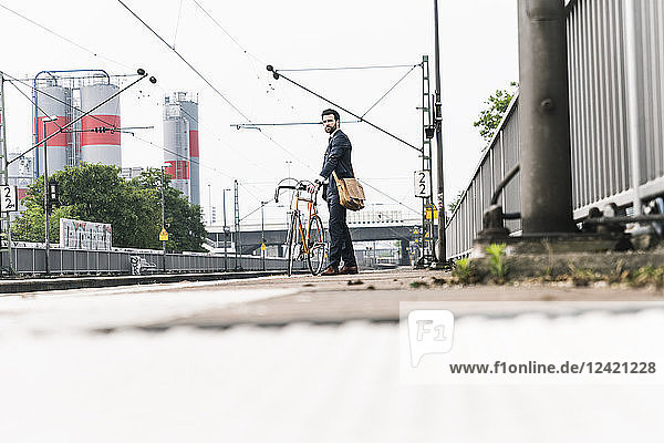 Businessman with bicycle waiting at the platform