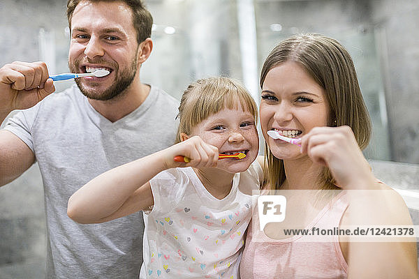 Happy family brushing teeth together