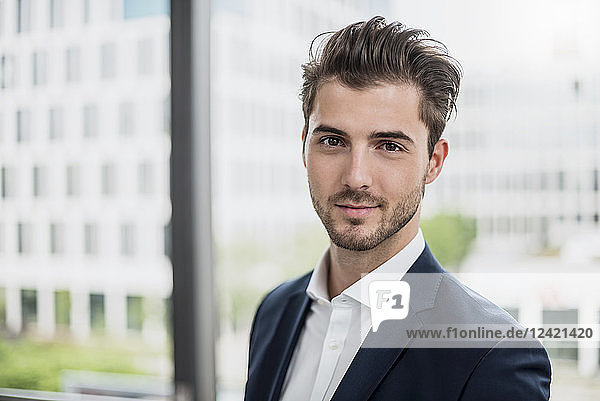 Portrait of confident young businessman at the window