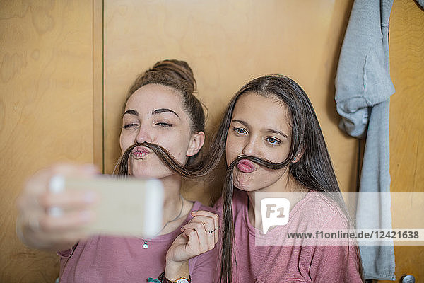 Playful happy teenage girls taking a selfie