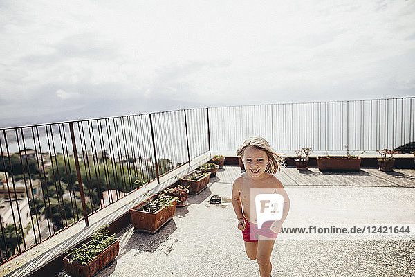Italy  Naples  happy little girl running on roof terrace