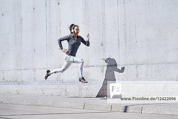Female jogger with headphones on street