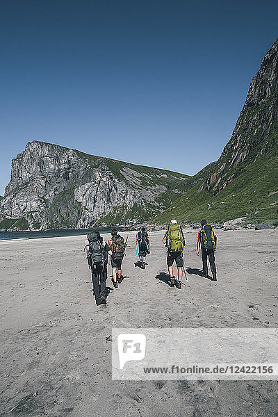 Norway  Lofoten  Moskenesoy  Young men hiking to Kvalvika Beach