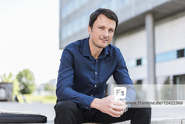Portrait of smiling businessman sitting outdoors