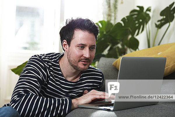 Man sitting at home  using laptop
