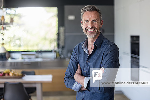 Portait of smiling mature man at home in kitchen