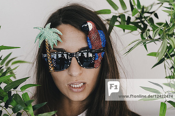 Young woman wearing exotic sunglasses with palm tree and parrot