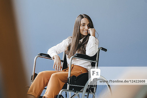 Young handicapped woman sitting in wheelchair  smiling