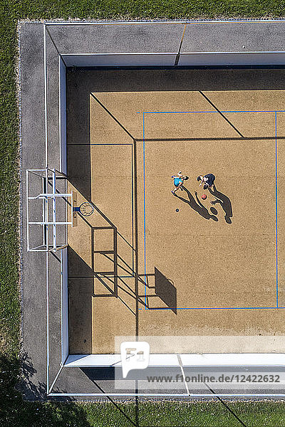 Young man and woman playing basketball  aerial view