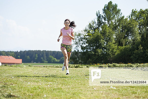 Young woman running on meadow