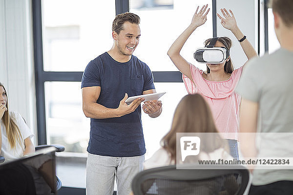 Teacher with tablet student wearing VR glasses in class