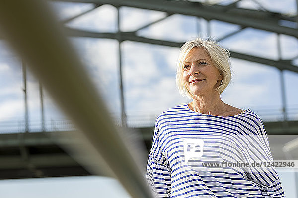 Portrait of smiling senior woman at a bridge