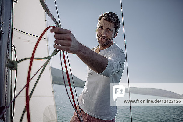 Smiling man standing on a sailing boat