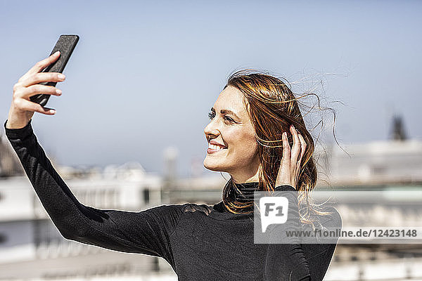 Portrait of smiling woman taking selfie with smartphone