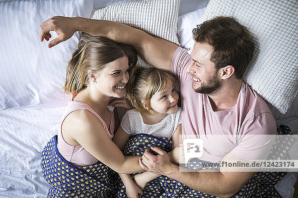 Happy family lying in bed  cuddling