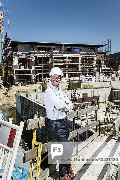 Portrait of smiling man wearing hard hat on construction site