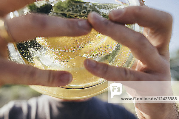 Detail of man drinking water infused with lemon and mint