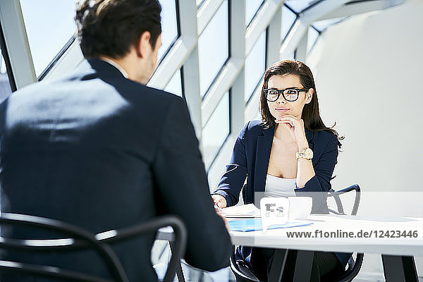 Businesswoman looking at businessman in modern office