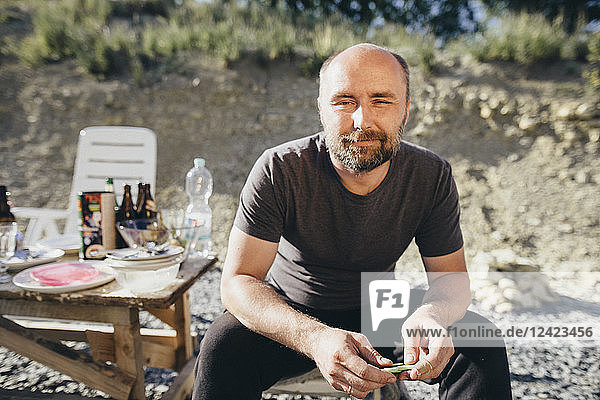 Portrait of smiling man with beard sitting outdoors