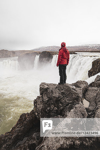 Iceland  man standing at Godafoss waterfall