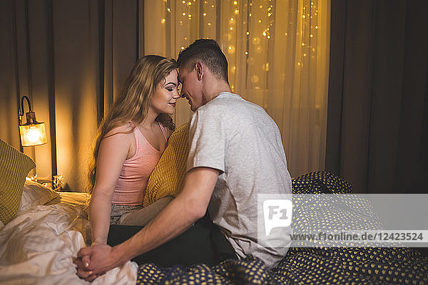 Romantic young couple sitting on bed