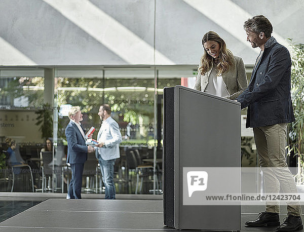 Smiling colleagues standing on stage at lectern