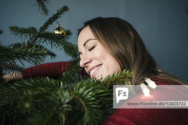 Happy woman hugging Christmas tree
