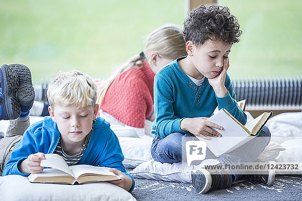Pupils reading books on the floor in school break room