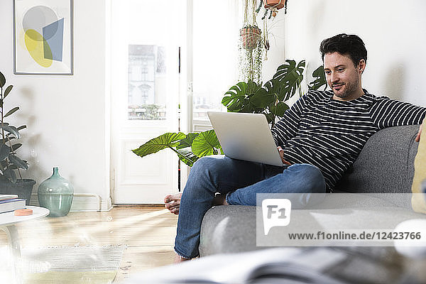 Man sitting at home  using laptop