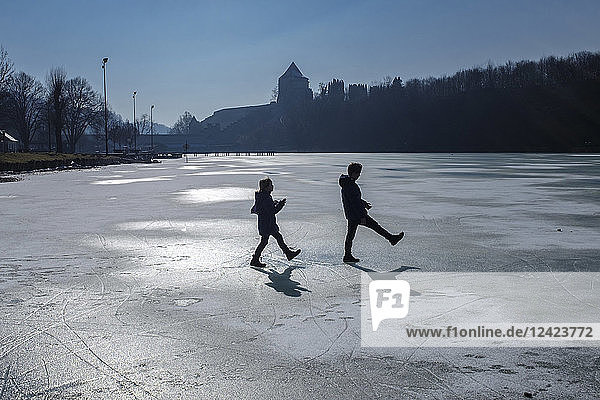 Two children playing on icy surface