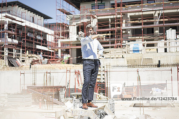 Smiling man standing on construction site holding a hammer