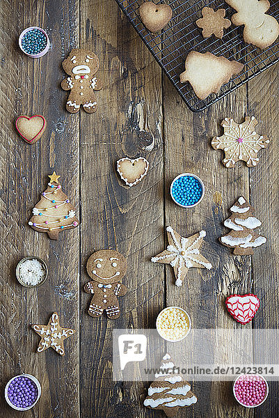 Decorated and unfinished gingerbread cookies on wood
