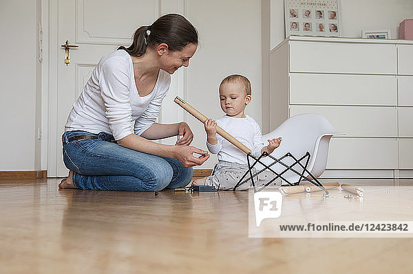 Mother and daughter assembling a chair at home