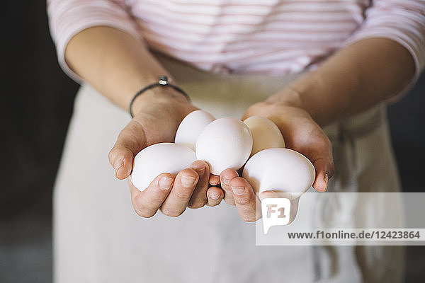 Woman holding raw white eggs