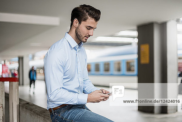 Businessman using cell phone at the station