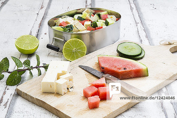 Lunch box,  preparation of watermelon salad with feta,  cucumber,  ment and lime dressing
