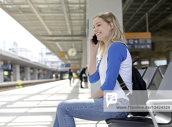 Young blond woman using smartphone at platform