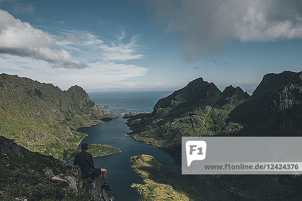 Norway   Lofoten  Traveller sitting on rock  looking over Agvatnet lake