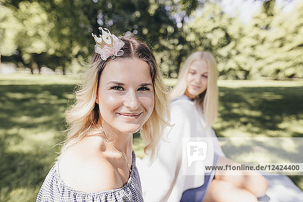 Portrait of two smiling young women relaxing in a park
