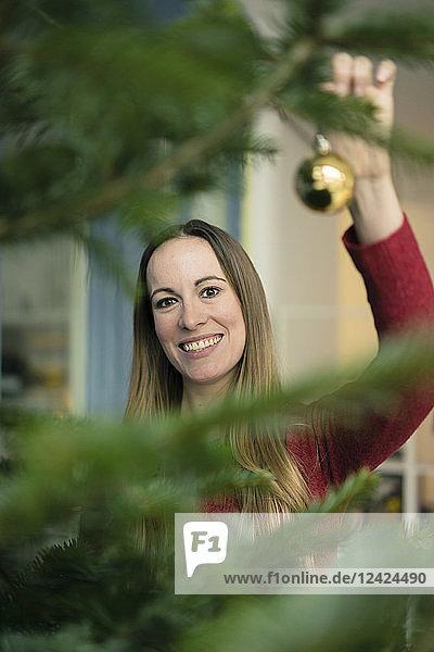 Portrait of smiling woman decorating Christmas tree
