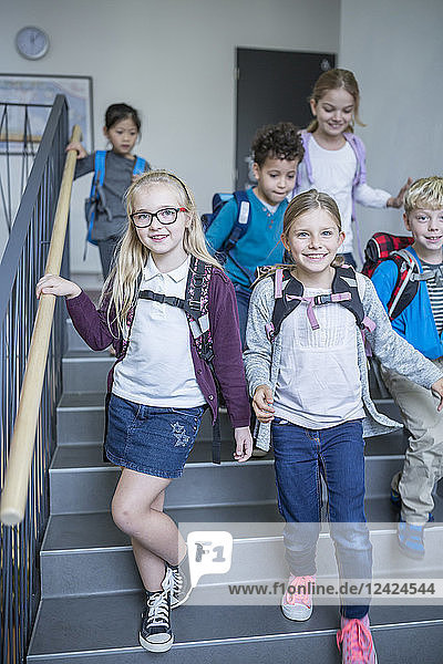 Happy pupils on staircase leaving school
