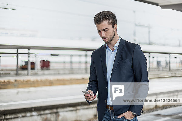 Businessman using cell phone at the platform