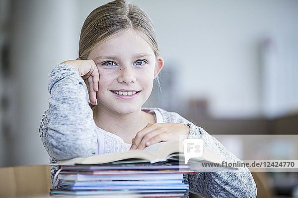 Portrait of smiling schoolgirl with books in school