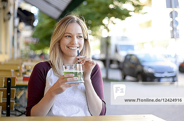 Blond young woman drinking 'Berliner Weisse' in beer garden