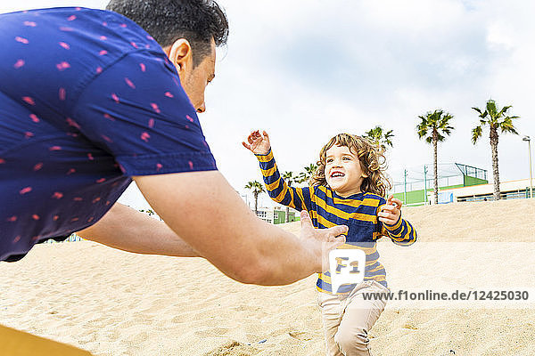 Spain  Barcelona  boy running toward his father on the beach