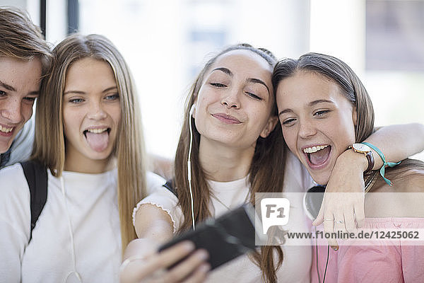 Happy students taking a selfie in school