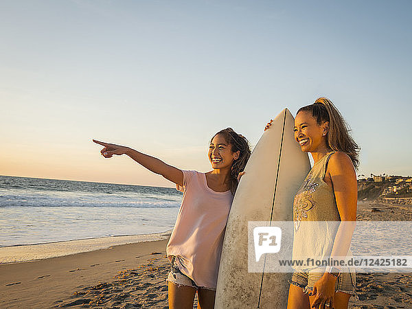 Mutter und Tochter mit Surfbrett