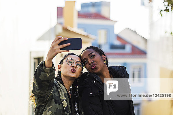 Zwei junge Frauen nehmen Selfie im Freien