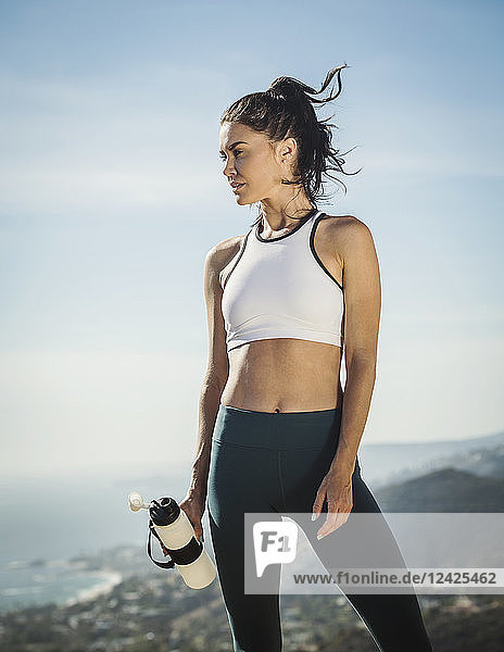 Frau in Sportkleidung mit Wasserflasche