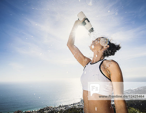 Frau gießt sich Wasser über den Kopf